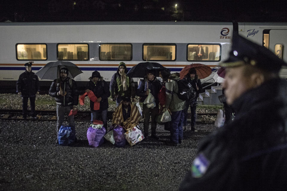 In this picture taken Saturday Dec. 14, 2019, a group of Pakistani migrants stands by the rail tracks after being taken off a train bound to the town of Bihac by Bosnian police in Bosanska Krupa, northwestern Bosnia. (AP Photo/Manu Brabo)