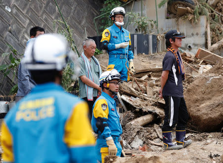 Family members of the missing people watch rescue and search operation by rescue workers at a landslide site caused by a heavy rain in Kumano Town, Hiroshima Prefecture, western Japan, July 11, 2018. REUTERS/Issei Kato