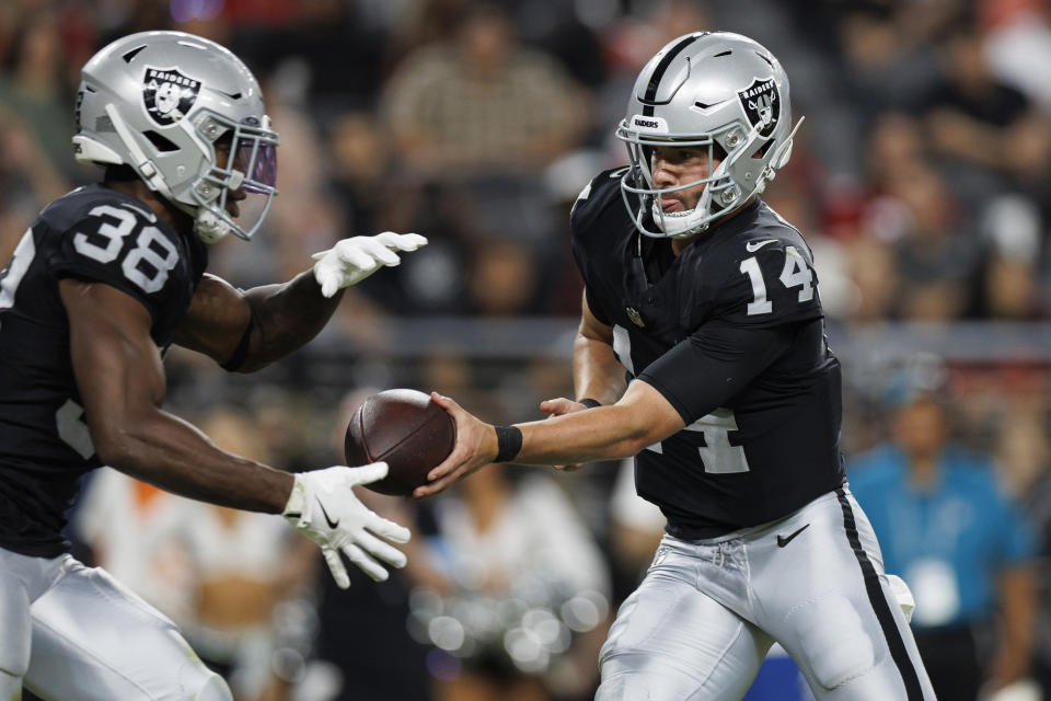 LAS VEGAS, NV - 23 AGUSTUS: Quarterback Carter Bradley #14 dari Las Vegas Raiders menyerahkan bola kepada running back Brittain Brown #38 selama kuartal keempat pertandingan sepak bola pramusim NFL melawan San Francisco 49ers, di Allegiant Stadium pada 23 Agustus 2024 di Las Vegas, Nevada. (Foto oleh Brooke Sutton/Getty Images)