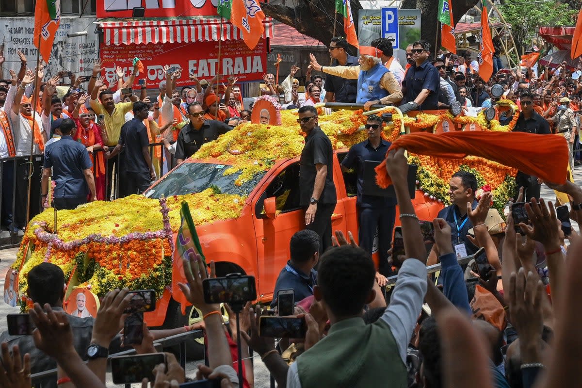 Indian prime minister Narendra Modi waves to supporters from atop a vehicle during a road rally held by the Bharatiya Janata Party (BJP) in Bengaluru ahead of the Karnataka assembly election (AFP via Getty Images)