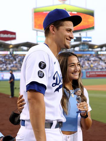 <p>Harry How/Getty</p> Corey Seager's wife Madisyn poses with him and a bobblehead of the athlete before a Dodgers game in September 2021.