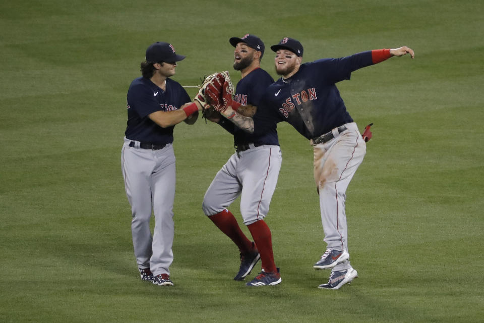 Boston Red Sox outfielders' Alex Verdugo, right, Kevin Pillar, center, and Andrew Benintendi celebrate after the baseball game against the New York Mets at Citi Field, Thursday, July 30, 2020, in New York. The Red Sox defeated the Mets 4-2. (AP Photo/Seth Wenig)