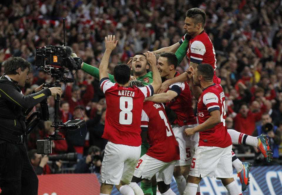 Arsenal players celebrate their win against Wigan Athletic at the end of their English FA Cup semifinal soccer match at Wembley Stadium in London, Saturday, April 12, 2014. (AP Photo/Sang Tan)