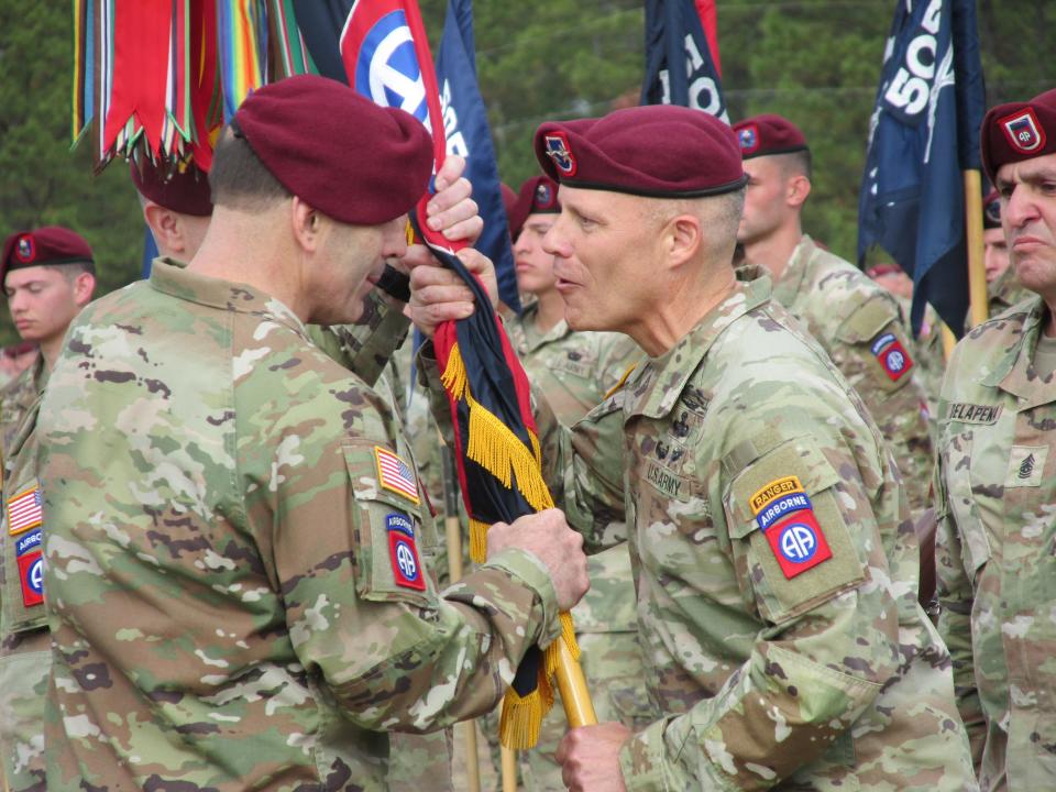 Maj. Gen. Christopher LaNeve, right, passes the 82nd Airborne Division colors to Lt. Gen. Christopher Donahue, left, 18th Airborne Corps commander, during a command change ceremony Friday, Nov. 17, 2023, on Pike Field at Fort Liberty.