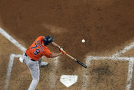 Houston Astros' Jose Abreu hits an RBI single against the Texas Rangers during the sixth inning in Game 5 of the baseball American League Championship Series Friday, Oct. 20, 2023, in Arlington, Texas. (AP Photo/Godofredo A. Vásquez)