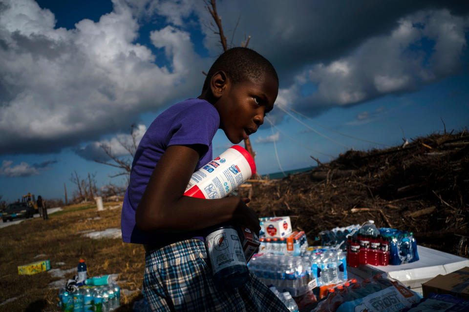 Ayfon Minus, 8, collects donated food that was brought by helicopter from Freeport to the Hurricane Dorian destroyed village of High Rock, Grand Bahama, Bahamas, Sept. 10, 2019. | Ramon Espinosa—AP