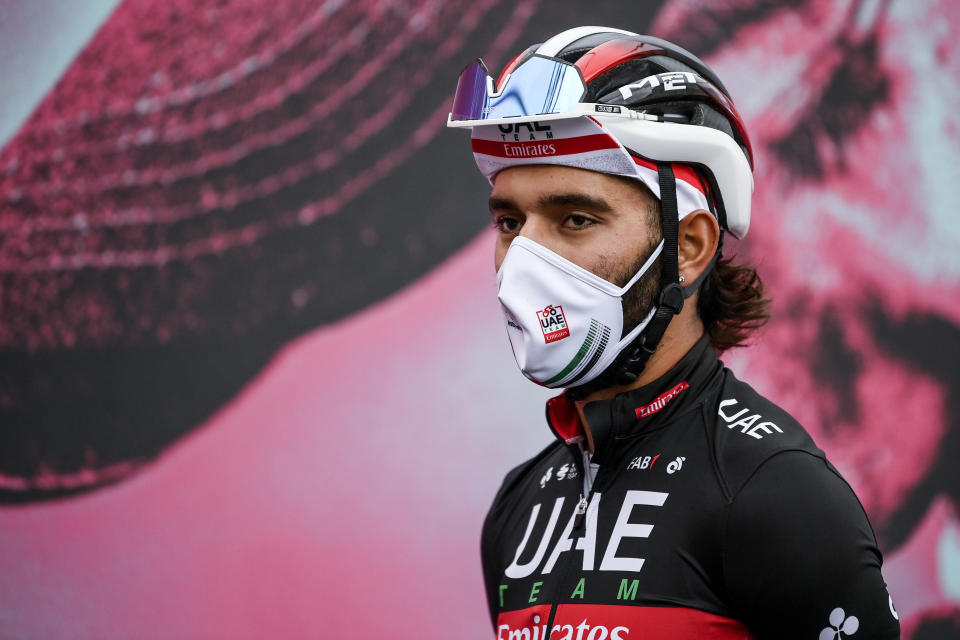 Cyclist Fernando Gaviria wears a face mask to curb the spread of COVID-19 as he attends the 13th stage of the Giro d'Italia cycling race, from Cervia to Monselice, Italy, on Friday, Oct. 16, 2020. Colombian sprinter Gaviria is the latest cyclist to test positive for the coronavirus and be withdrawn from the Giro d’Italia. Gaviria and a staff member for Team AG2R La Mondiale were the only positives out of 492 tests carried out Sunday and Monday, Oct. 19, 2020. (Marco Alpozzi/LaPresse via AP)