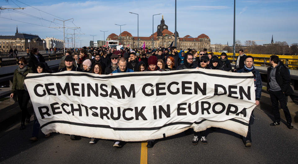 Hinter einem Plakat mit der Aufschrift "Gemeinsam gegen den Rechtsruck in Europa" stehen Demonstranten. Mit Kundgebungen an zentralen Orten in Dresden haben die Proteste gegen einen geplanten Aufmarsch von Rechtsextremen anlässlich des 75. Jahrestags der Bombardierung Dresdens begonnen. Foto: Oliver Killig / dpa-Zentralbild / dpa