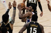 Philadelphia 76ers center Joel Embiid (21) is defended by Atlanta Hawks' John Collins (20) and Clint Capela (15) as he looks for an opening during the first half of Game 6 of an NBA basketball Eastern Conference semifinal series Friday, June 18, 2021, in Atlanta. (AP Photo/John Bazemore)