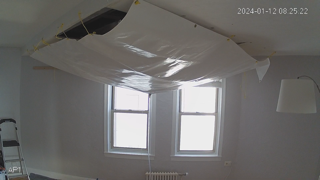 J-Michael Roberts put up a tarp covering his damaged ceiling in his condominium at the Santander building in Asbury Park. The collected water drains into a hose that flows into the tub in the bathroom.