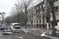 Damaged cars and a destroyed accommodation building are seen near a checkpoint in Brovary, outside Kyiv, Ukraine, Tuesday, March 1, 2022. Russian shelling pounded civilian targets in Ukraine's second-largest city Tuesday and a 40-mile convoy of tanks and other vehicles threatened the capital — tactics Ukraine's embattled president said were designed to force him into concessions in Europe's largest ground war in generations. (AP Photo/Efrem Lukatsky)