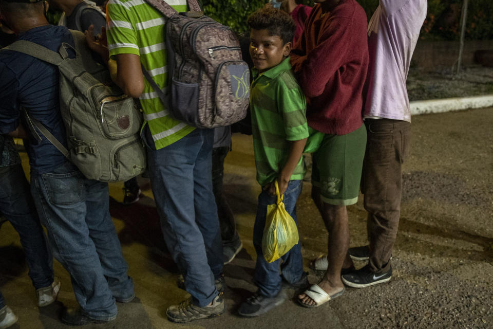 Migrants from Honduras stand in line waiting for aid during their journey to the United States-Mexican border, in Morales, Guatemala, Thursday, Oct. 1, 2020. Honduran migrants hoping to reach the U.S. entered Guatemala on foot Thursday, testing the newly reopened frontier that had been shut due to the new coronavirus pandemic. (AP Photo/Moises Castillo)