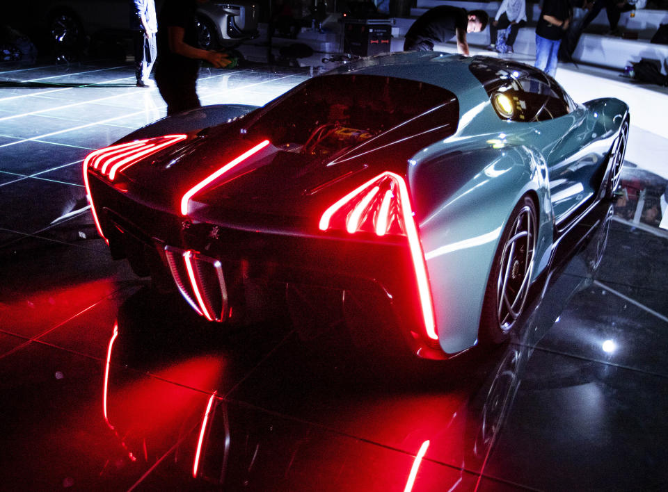 A woman cleans the prototype of a Chinese car at the IAA Auto Show in Frankfurt, Germany, Monday, Sept. 9, 2019. The IAA officially starts with media days on Tuesday and Wednesday. (AP Photo/Michael Probst)