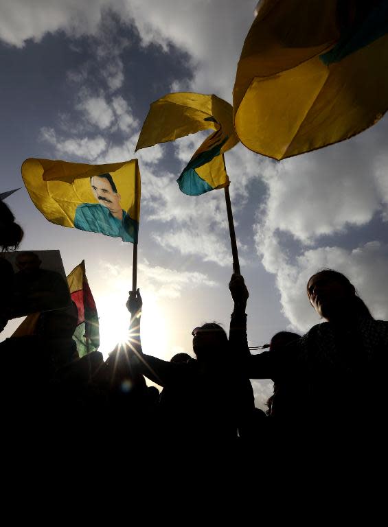 Kurdish supporters of the Kurdistan Workers Party (PKK) wave flags bearing portraits of PKK's leader Abdullah Ocalan during a demonstration in the northern Iraqi city of Arbil, on February 15, 2015