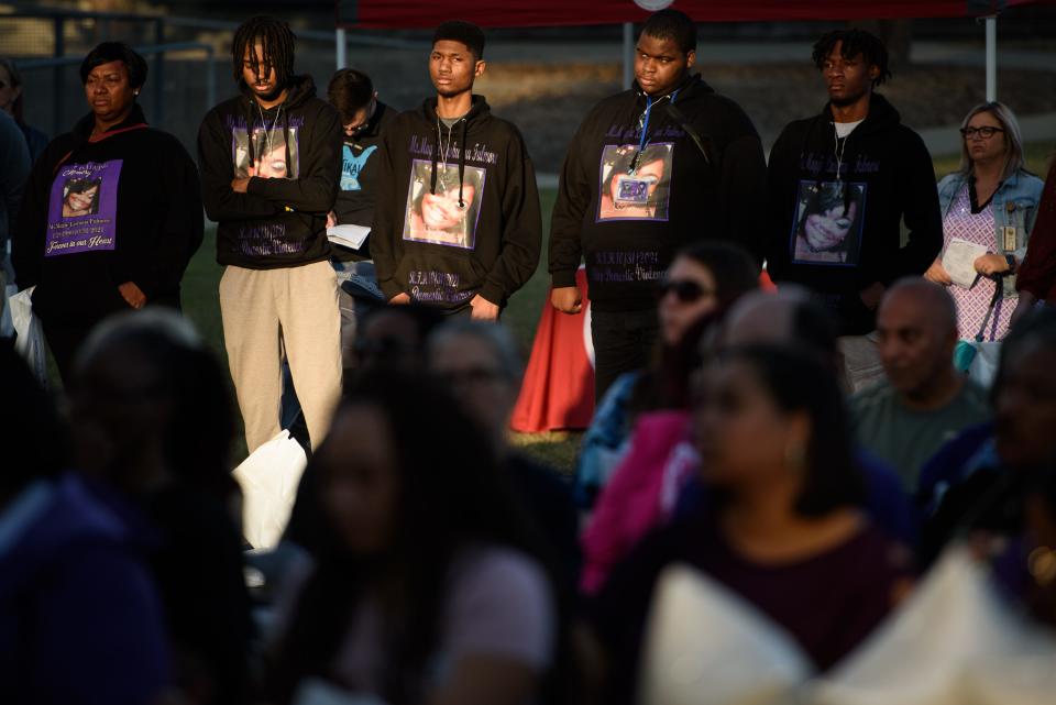 Friends and family of Maggie Lashauna Fulmore wear hoodies featuring her photo in her memory at the Remember My Name domestic violence vigil at Festival Park on Thursday, Oct. 6, 2022. Fulmore was shot and killed by her former boyfriend last October.