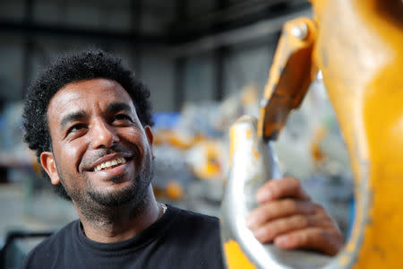 Merhawi Tesfay, an immigrant from Eritrea poses during a Reuters interview at German plant engineering firm Kremer Machine Systems where he found a job as electrician and plant manufacturer in Gescher near Muenster, Germany, August 4, 2017. REUTERS/Wolfgang Rattay