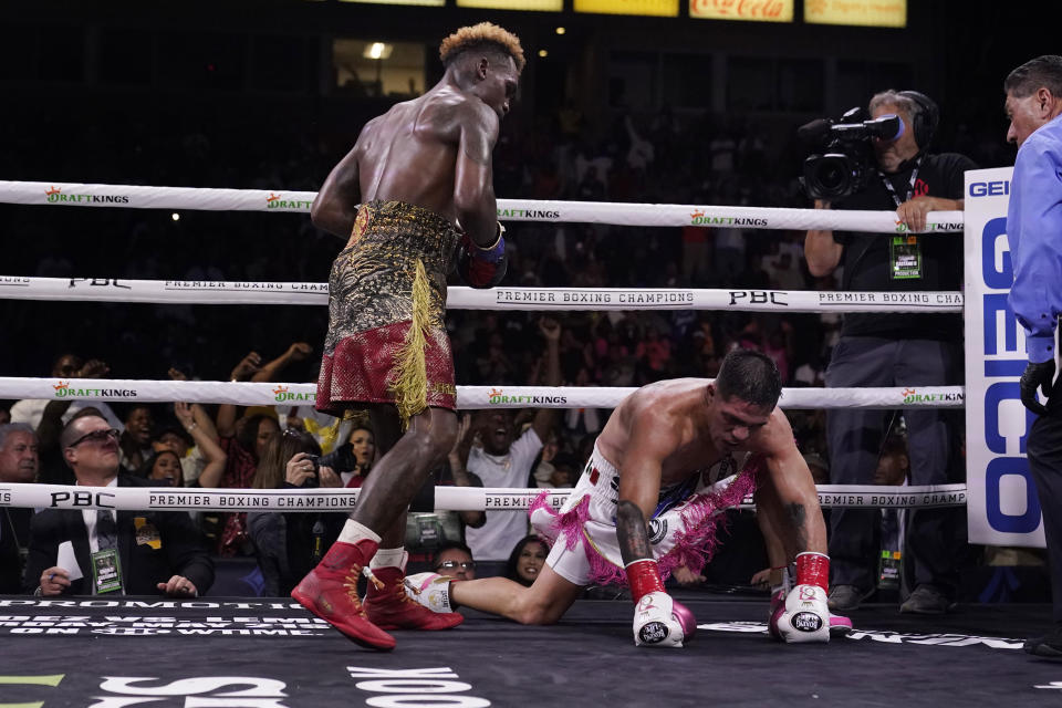 Jermell Charlo, left, stands next to Brian Castano after sending Castano to the mat for the second time during the 10th round of a super welterweight boxing title bout Saturday, May 14, 2022, in Carson, Calif. (AP Photo/Marcio Jose Sanchez)