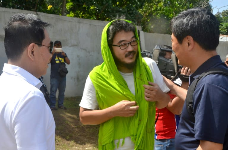 Released South Korean hostage Park Chung Hung (C), the captain of a cargo ship, talks to local government officials at Jolo airport on southern Philippine island of Mindanao, on January 14, 2017