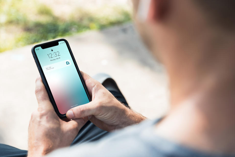 Person holding smartphone showing a notification, indicative of receiving messages or updates during work hours