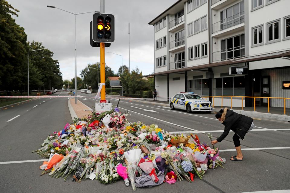 A woman lays flowers at a Christchurch memorial for the mosque victims (Jorge Silva/Reuters)