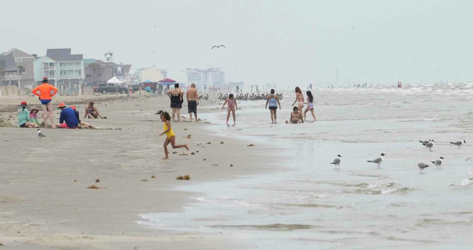 People play on the beach after a soft reopening of part of Galveston Island State Park last June.