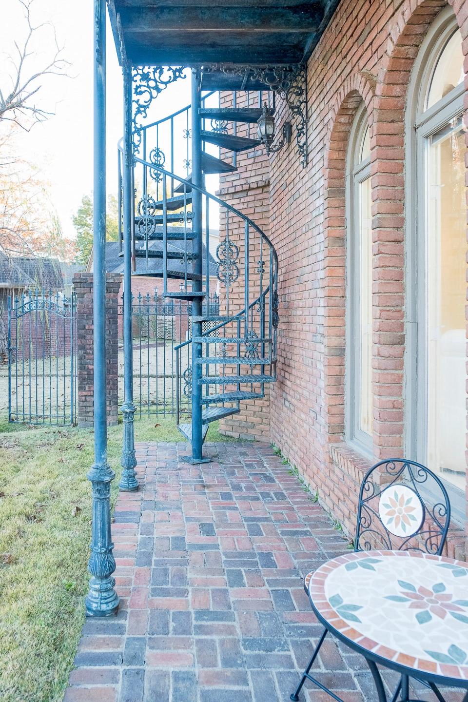 A circular staircase gives additional access to the patio seating area in the backyard.