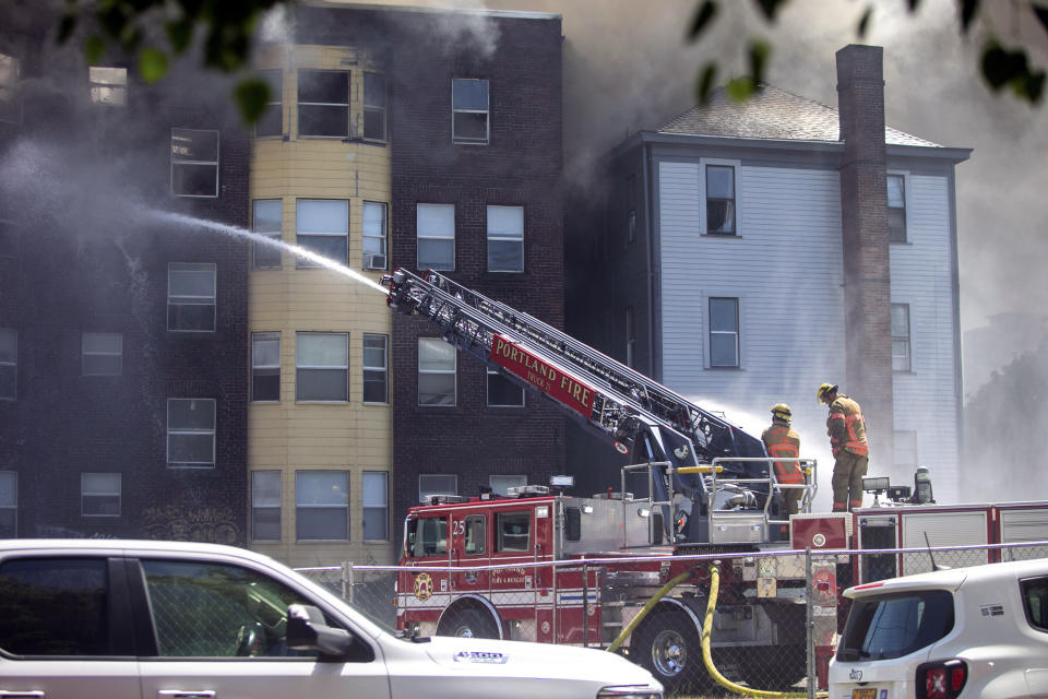 Portland Fire & Rescue work at the scene of a major apartment fire in downtown Portland, Ore., Tuesday, May 16, 2023. Firefighters rescued people and at least one dog from a dramatic, three-alarm apartment fire in downtown Portland on Tuesday before they were ordered to fall back. (Sean Meagher/The Oregonian via AP)