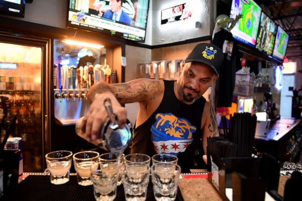 PHOTO: Rob Koski, a bartender at Salty Jim's Island Bar & Grill, pours a round of Lemon Drops for customers having a hurricane party at the bar in Sarasota, Fla., Sept. 28, 2022. (Mike Lang/Sarasota Herald-Tribune via USA Today Network)