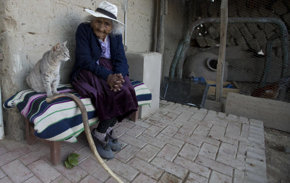 In this Aug. 23, 2018 photo, 117-year-old Julia Flores Colque and her cat "Minina" sit outside their home in Sacaba, Bolivia. Flores Colque's longevity is striking in Bolivia, which still has one of South America's highest levels of mortality, according to the Economic Commission for Latin America and the Caribbean, the U.N.'s regional arm. (AP Photo/Juan Karita)