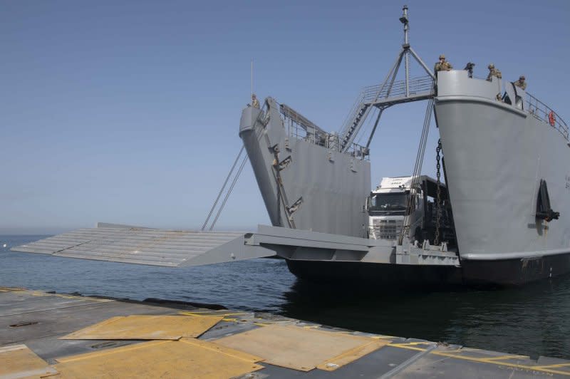 The bow ramp on the U.S. Army's LSV-5 lowers onto the Trident Pier to unload trucks carrying humanitarian aid in May. Inspectors general offices of the Defense Department and U.S. Agency for International Development announced Thursday they are jointly reviewing Gaza maritime aid delivery via the pier built by the U.S. military. File Photo via U.S. Army/UPI