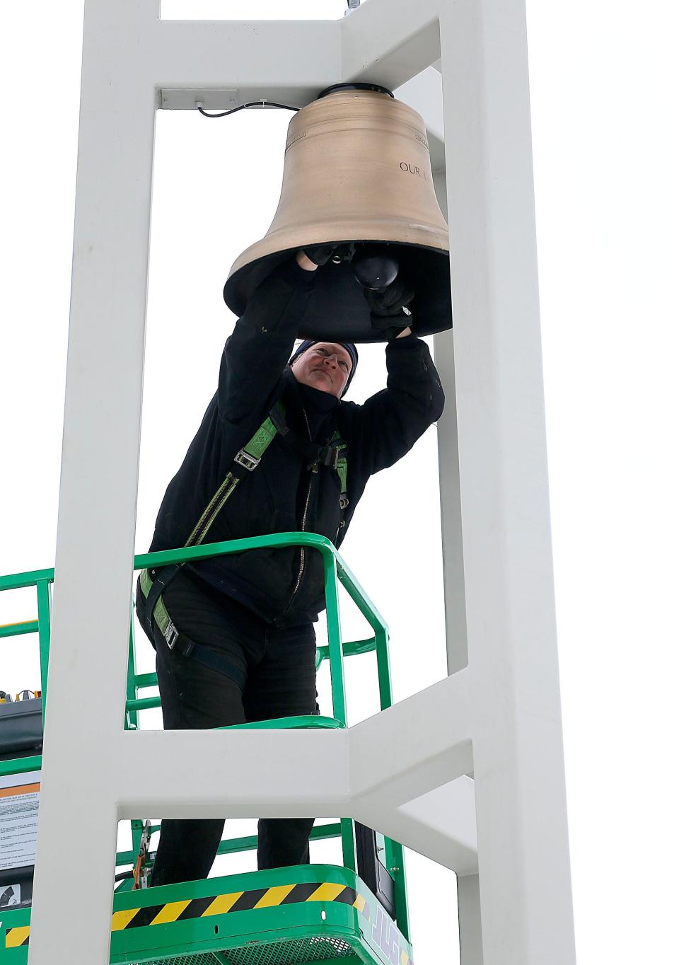 Todd Hultzman, a contractor for the Verdin Bells &amp; Clock Co., makes adjustments to the ball as the bell was installed at St. Edward Catholic Church on Tuesday. A blessing of the bell will be held Sunday.