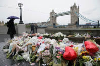 <p>A woman at looks at flowers placed for attack victims at Potters Field Park in London, Tuesday, June 6, 2017. (Photo: Tim Ireland/AP) </p>