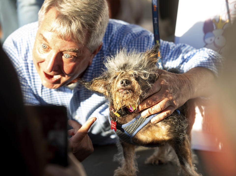 Scamp the Tramp celebrates after taking top honors in the World's Ugliest Dog Contest at the Sonoma-Marin Fair in Petaluma, Calif., Friday, June 21, 2019. At left is Kerry Sanders, one of the judges. (AP Photo/Noah Berger)