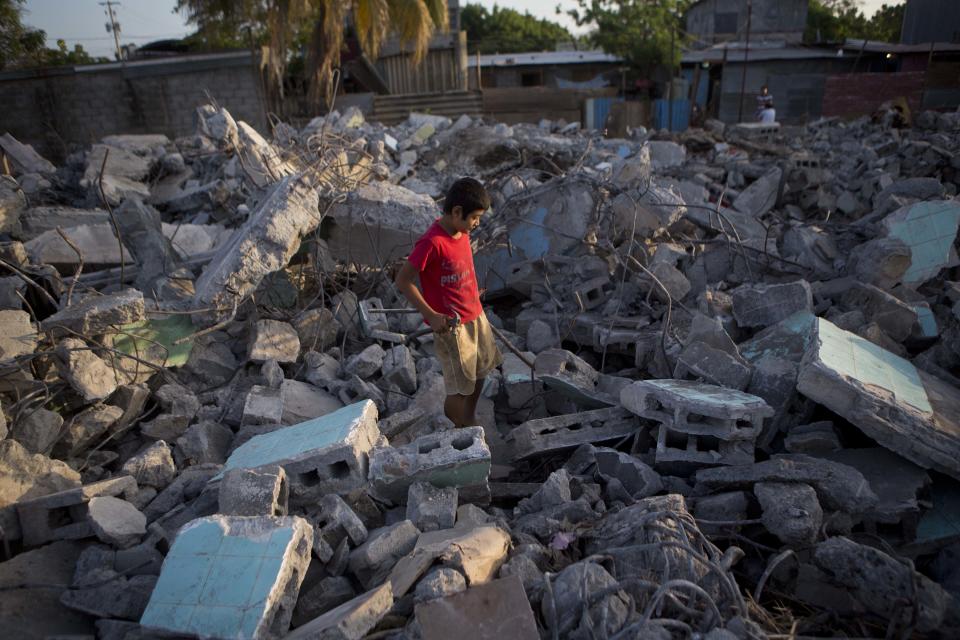 A boy searches for metal to sell, in the rubble of a building that was damaged in a 1972 earthquake and demolished after several recent earthquakes in Managua, Nicaragua, Monday, April 14, 2014. People who had been living in earthquake damaged buildings were ordered to evacuate after several quakes have affected Nicaragua since Thursday. (AP Photo/Esteban Felix)