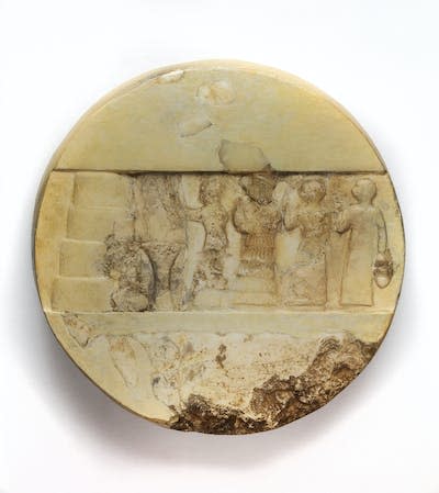 Relieve encontrado en una cámara del templo Larsa de Nin-Gal (el Gig-par-ku).Es un disco de calcita blanca; en un lado hay un panel con una escena de sacrificio en relieve (la figura del medio es Enheduanna) y en el otro una inscripción de Enheduanna, hija de Sargón de Akkad. <a href="https://www.penn.museum/collections/object/293415" rel="nofollow noopener" target="_blank" data-ylk="slk:Penn Museum;elm:context_link;itc:0;sec:content-canvas" class="link ">Penn Museum</a>