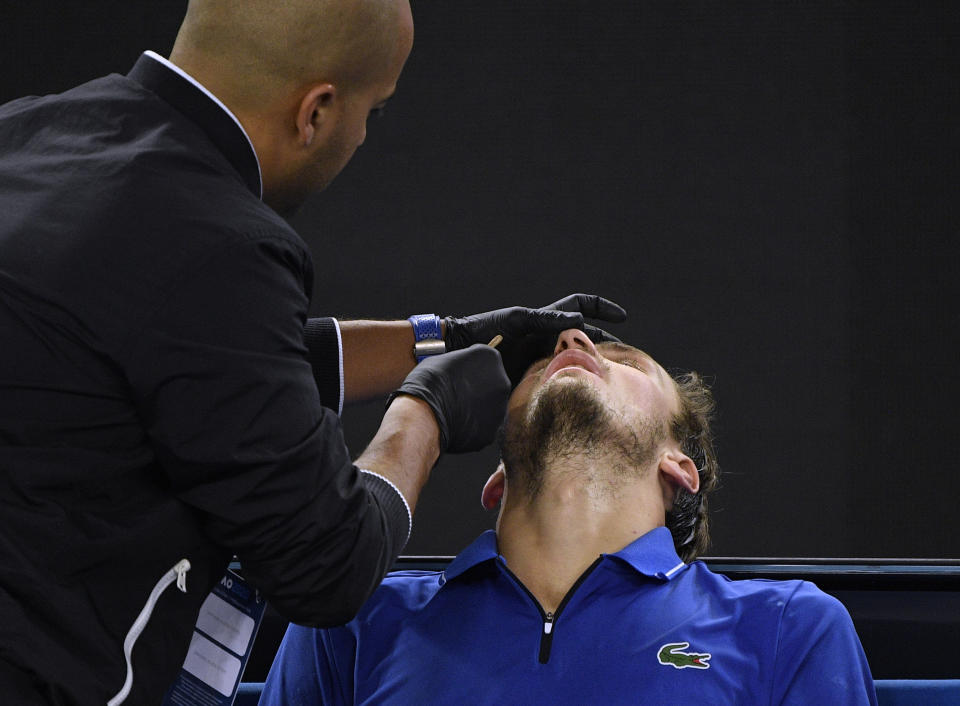 Russia's Daniil Medvedev receives treatment from trainer for a nosebleed during his second round singles match against Spain's Pedro Martinez at the Australian Open tennis championship in Melbourne, Australia, Thursday, Jan. 23, 2020. (AP Photo/Andy Brownbill)