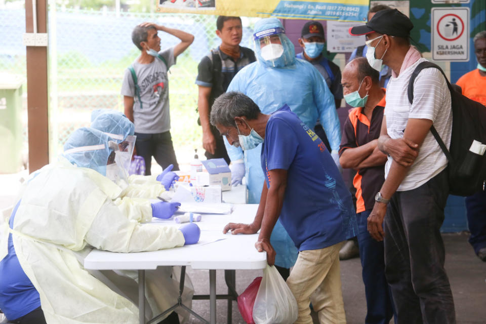 Health Ministry personnel screen the homeless for Covid-19 before sending them to transit centres during the MCO March 30, 2020. — Picture by Choo Choy May.