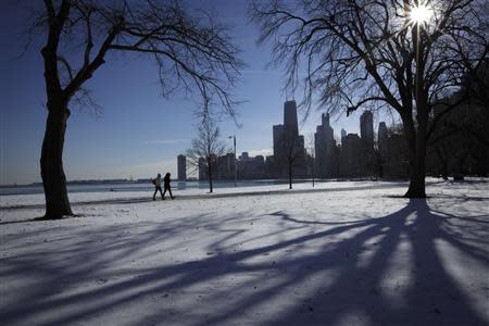 Two women walk along the shore of Lake Michigan in Chicago where temperatures have dropped well below freezing, December 12, 2013. REUTERS/John Gress