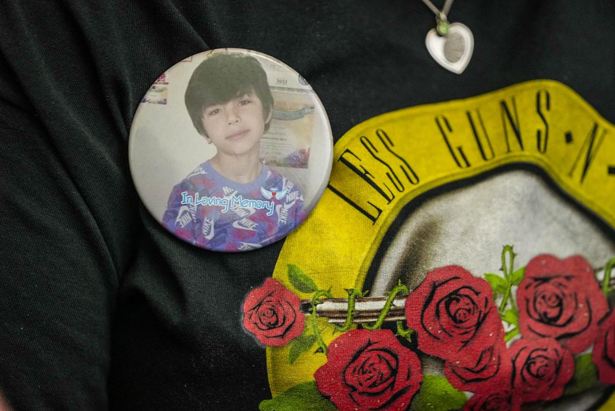 Nicole Cross wears a pin with a photo of Robb Elementary School shooting victim Uziyah “Uzi” Garcia while speaking with Sen. Roland Gutierrez in April. Most Texans support raising the minimum age to buy a gun from 18 to 21 years of age, according to a new poll by the University of Texas and the Texas Politics Project.