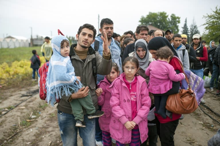 Migrants and refugees queue to enter a camp after crossing the Greek border into Macedonia near Gevgelija on October 8, 2015