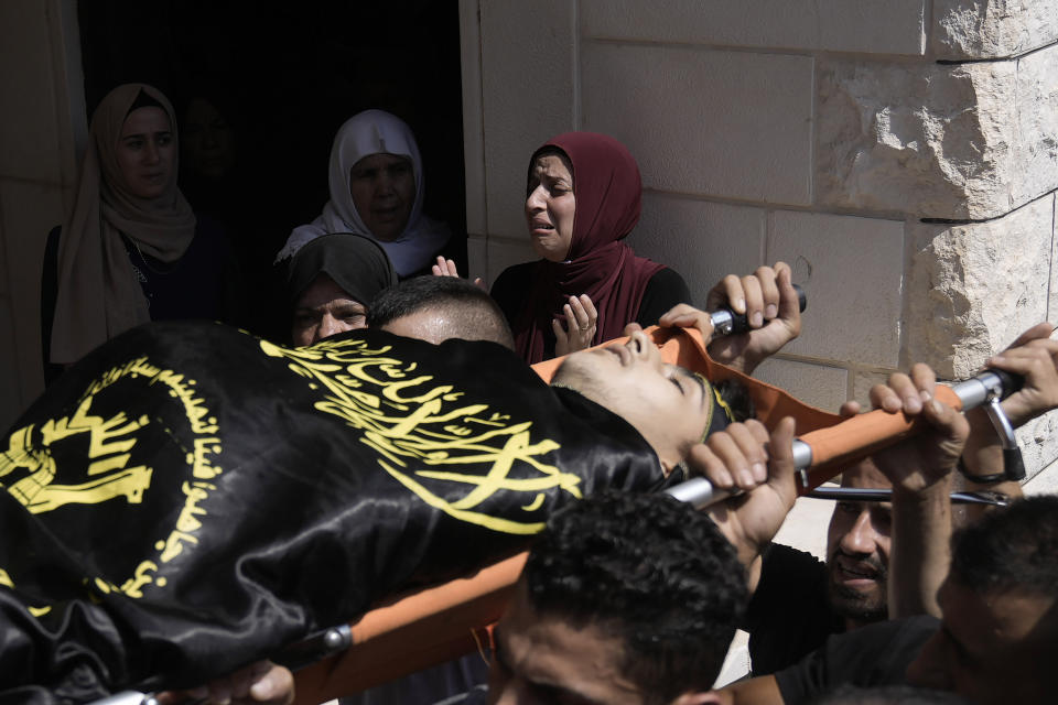 Mourners carry the body of Abdallah Abu Hasan, an 18-year-old militant Palestinian authorities said was killed by Israeli fire Friday morning, during his funeral in the village of Al-Yamoun, near the West Bank city of Jenin, Friday, Sept. 22, 2023. Hasan's body is wrapped in a Islamic Jihad flag — the group claimed Hasan as one of its militant fighters. The Israeli army said the incident occurred during a nighttime raid into the West Bank, after Palestinians fired and threw explosives at soldiers in the town of Kafr Dan. Soldiers shot back, hitting Hasan. (AP Photo/Majdi Mohammed)