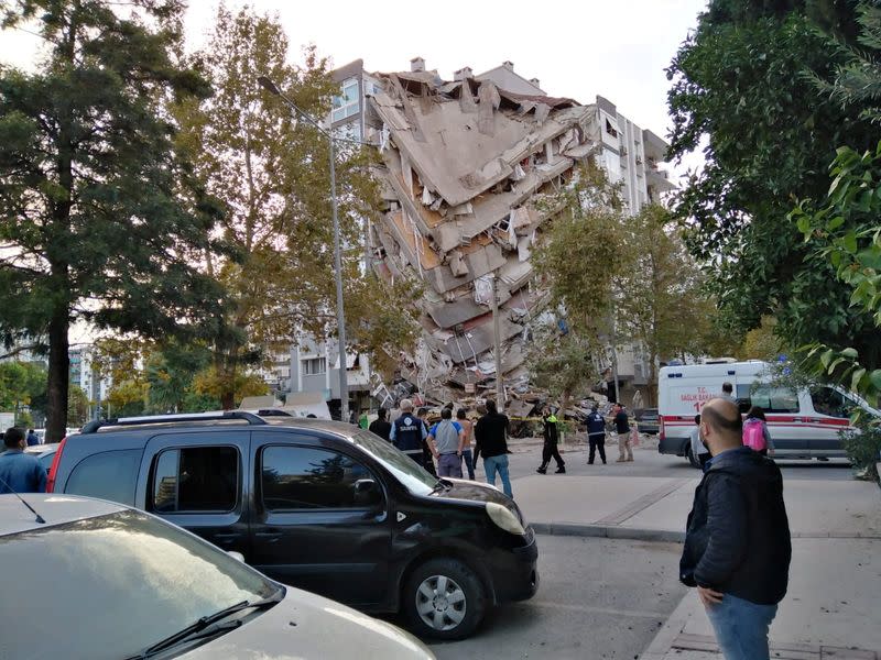 Residentes observan los daños a un edificio en la provincia turca de Izmir tras un fuerte terremoto