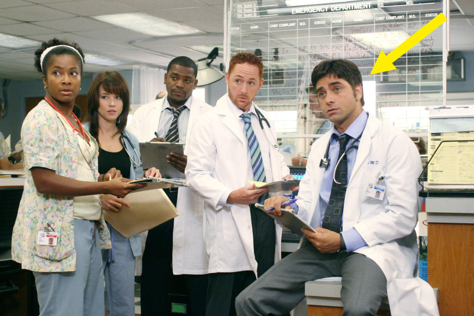 John Stamos sitting in a chair in a scene from "ER"