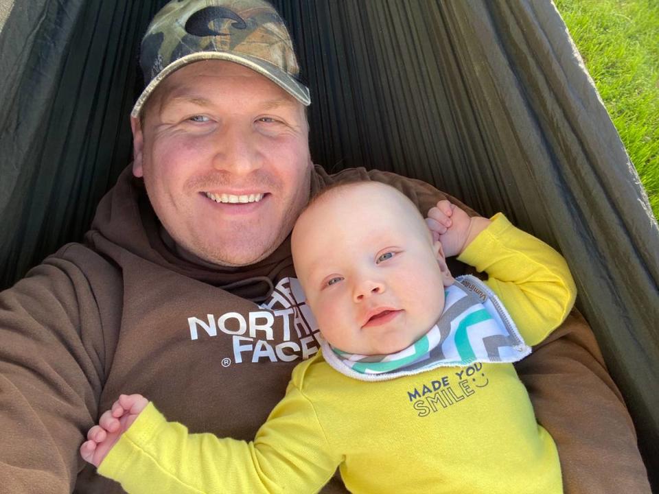 Douglas Moore cuddles in a hammock with his son, Jackson, in March 2020.