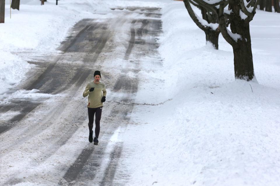 Matt Pazderak runs along Park Drive on Monday in Stow. The Akron-Canton region was hit with about a foot of snow late Sunday into Monday.