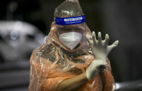 A Chinese tourist from Shanghai adjusts her gloves upon arrival at Suvarnabhumi airport on a special tourist visa, in Bangkok, Thailand, Tuesday, Oct. 20, 2020. Thailand on Tuesday took a modest step toward reviving its coronavirus-battered tourist industry by welcoming 39 visitors who flew in from Shanghai, the first such arrival since normal traveler arrivals were banned almost seven months ago. (AP Photo/ Wason Wanichakorn)