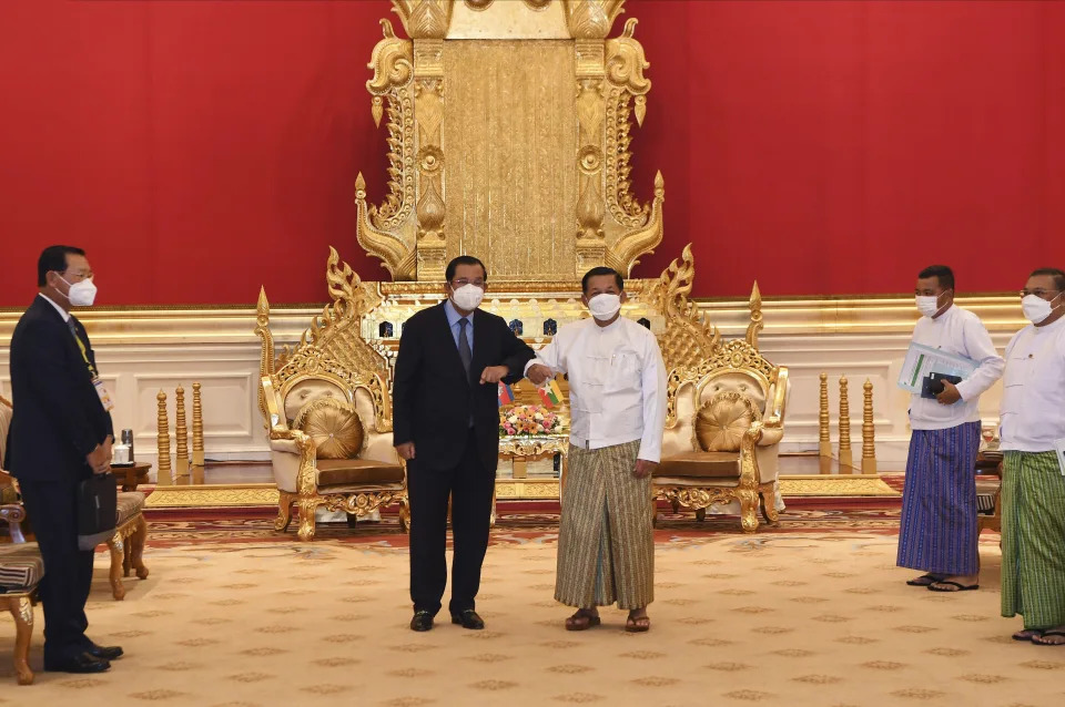 In this photo provided by An Khoun Sam Aun/National Television of Cambodia, Cambodian Prime Minister Hun Sen, center left, greets with Myanmar State Administration Council Chairman, Senior General Min Aung Hlaing, center right, during a meeting in Naypyitaw, Myanmar, Friday Jan. 7, 2022. Cambodian Prime Minister Hun Sen's visit to Myanmar seeking to revive peace efforts after last year's military takeover has provoked an angry backlash among critics, who say he is legitimizing the army's seizure of power. (An Khoun SamAun/National Television of Cambodia via AP)