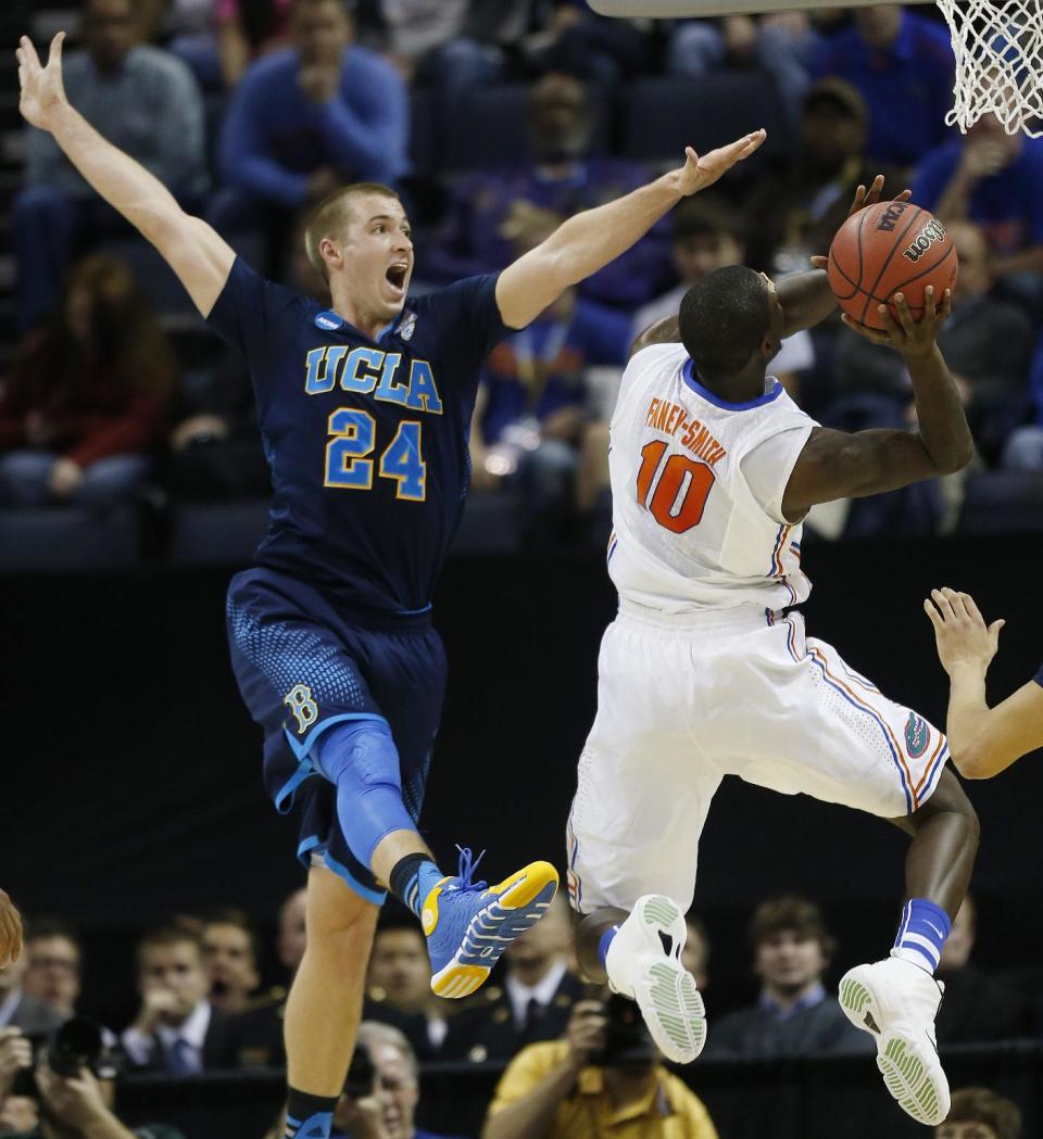 Florida forward Dorian Finney-Smith (10) shoots against UCLA forward Travis Wear (24) during the first half in a regional semifinal game at the NCAA college basketball tournament, Thursday, March 27, 2014, in Memphis, Tenn. (AP Photo/John Bazemore)