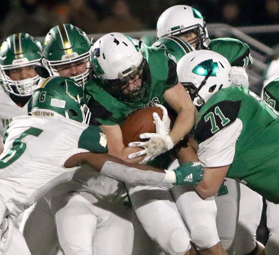 West Branch running back Steven Marra, center, in between Warrior lineman Caleb Adams (71) and Ursuline defenders, left, during the Division IV regional final at South Range Raiders Stadium Friday, November 19, 2021.