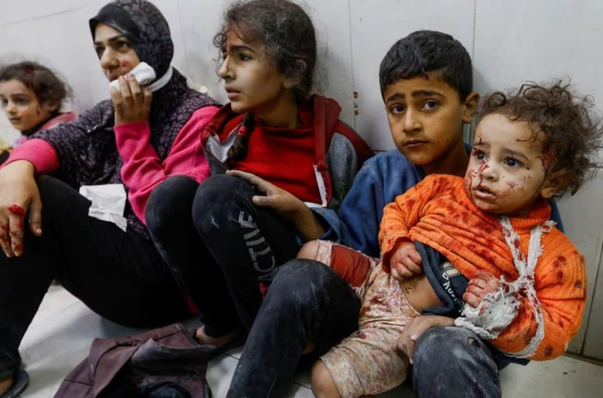 Wounded young Palestinians sit on the floor at Gaza's Nasser hospital following Israeli strikes (Reuters)